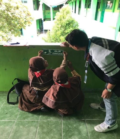 Pendampingan Pemasangan Tanda Jalur Evakuasi pada Bangunan Sekolah di Desa Hadiluwih: Mahasiswa KKN Teknik Geodesi Berperan dalam Mitigasi Bencana