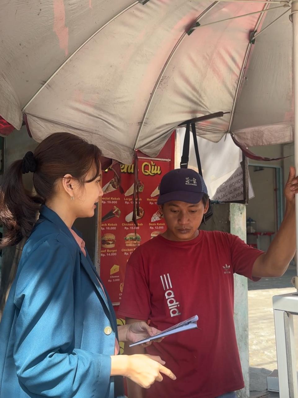 A person and person standing under an umbrellaDescription automatically generated